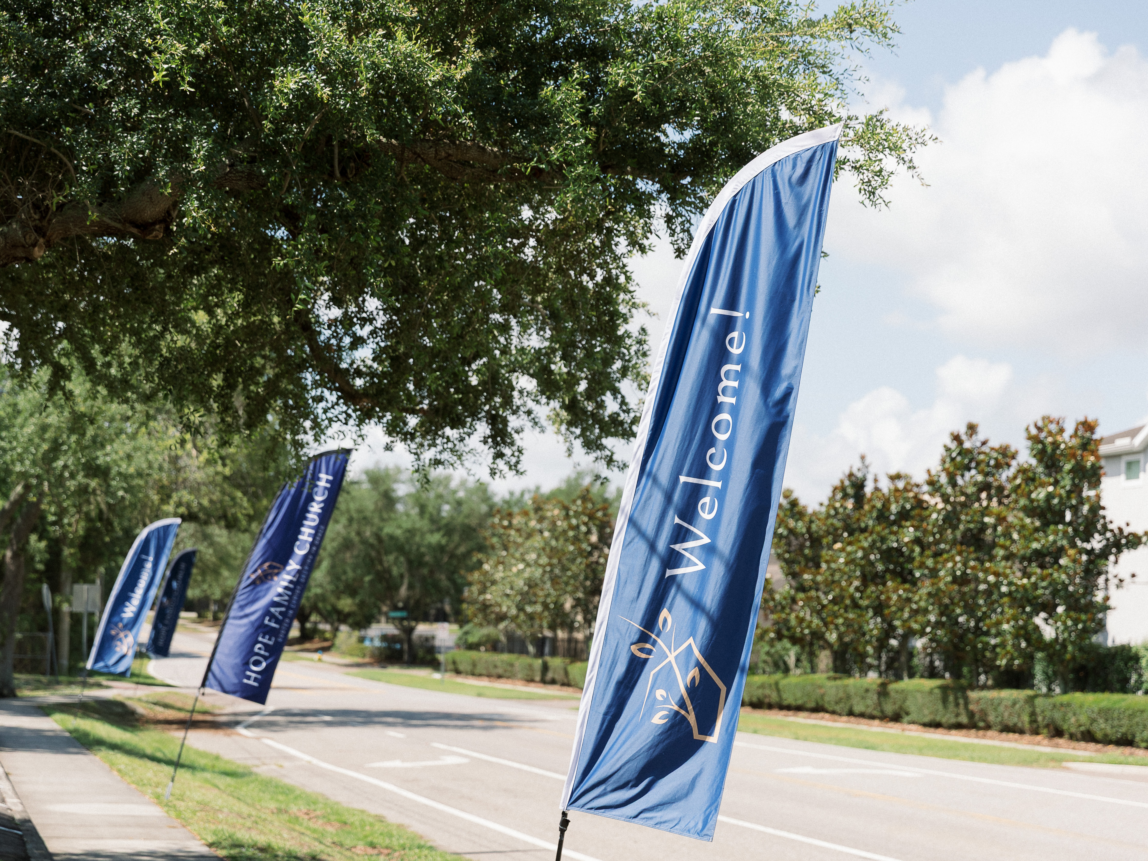Hope Family Church welcome banners along tree-lined street
