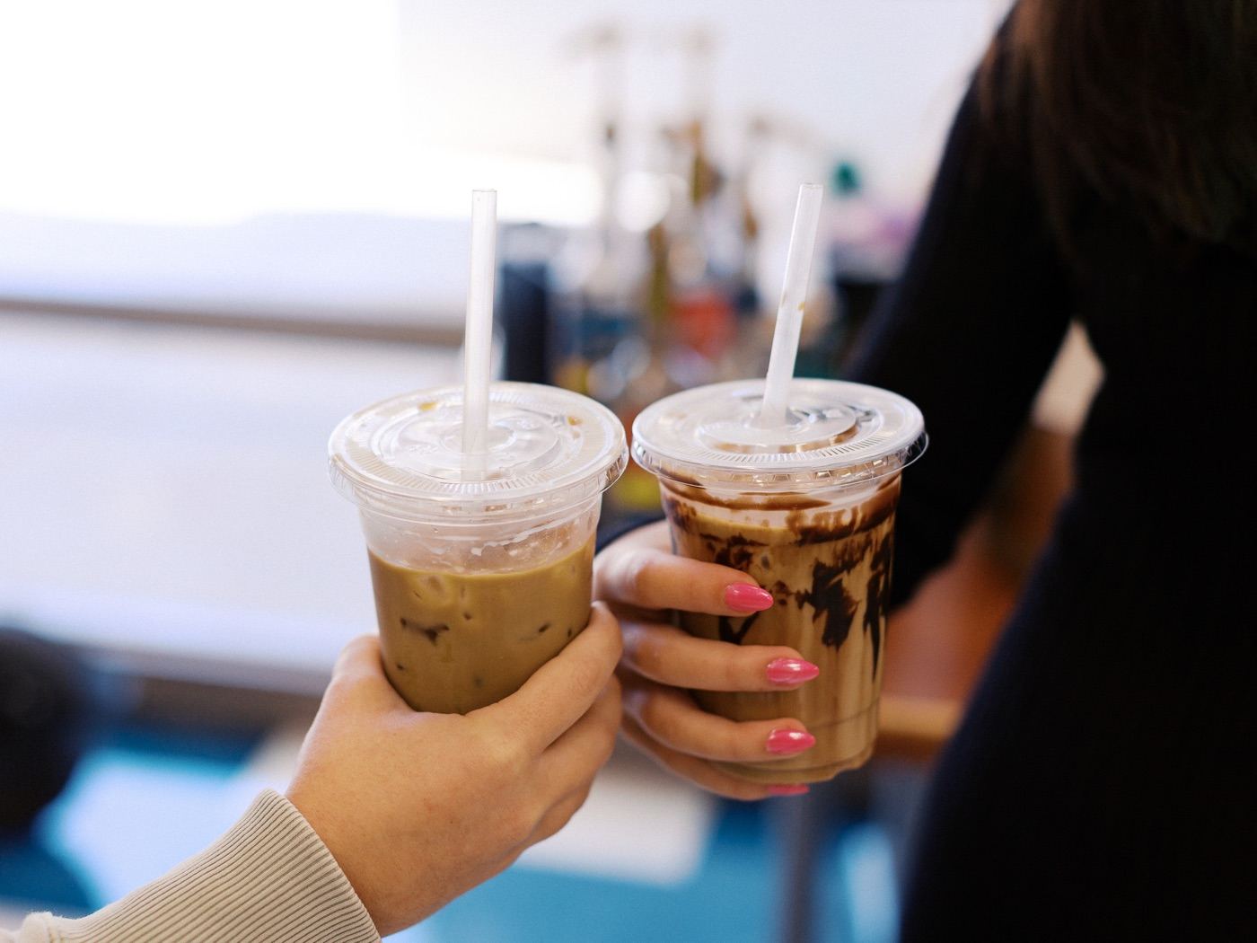 Two iced coffee drinks being held together at the Hope Family Church coffee bar